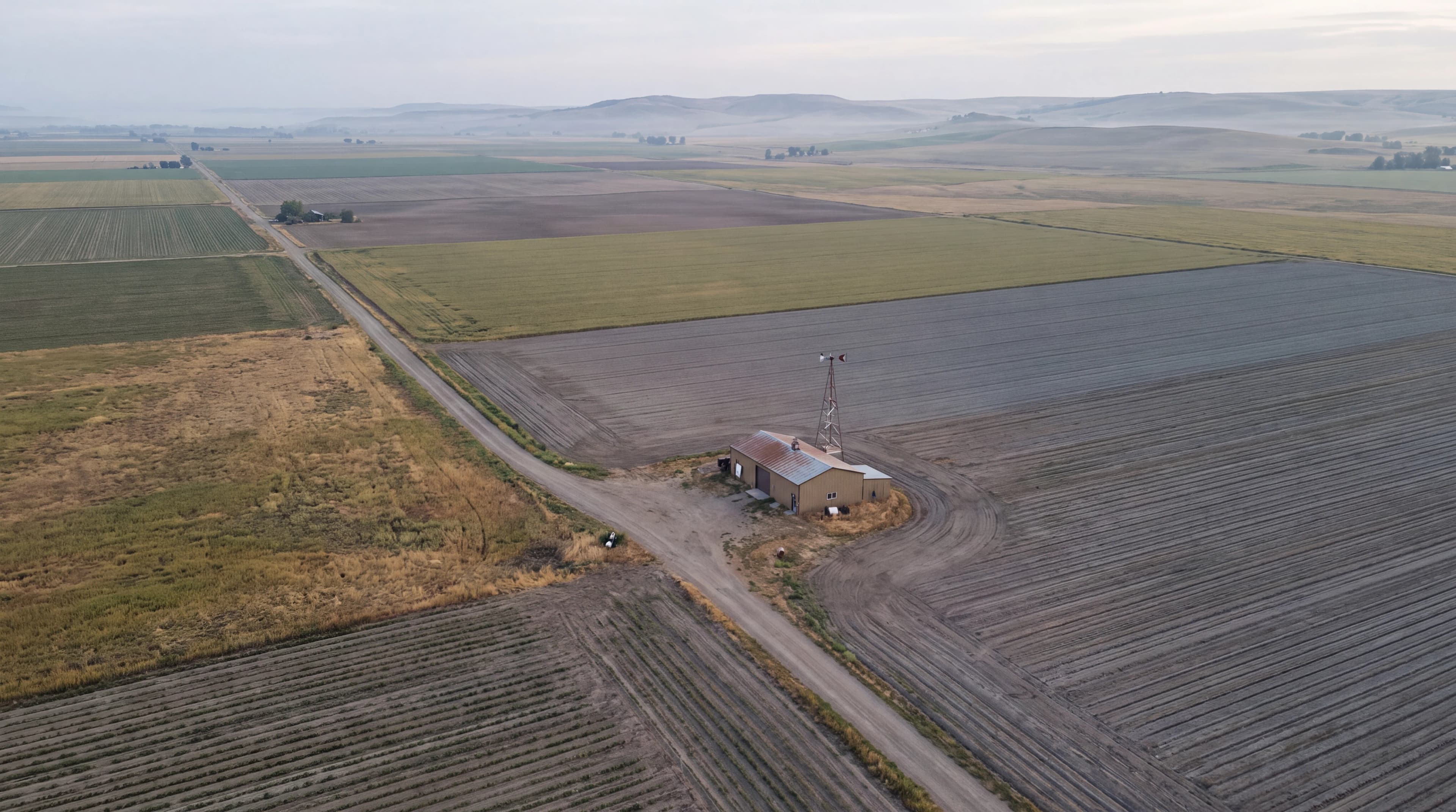 Generated aerial view of agricultural fields and a rural operations building