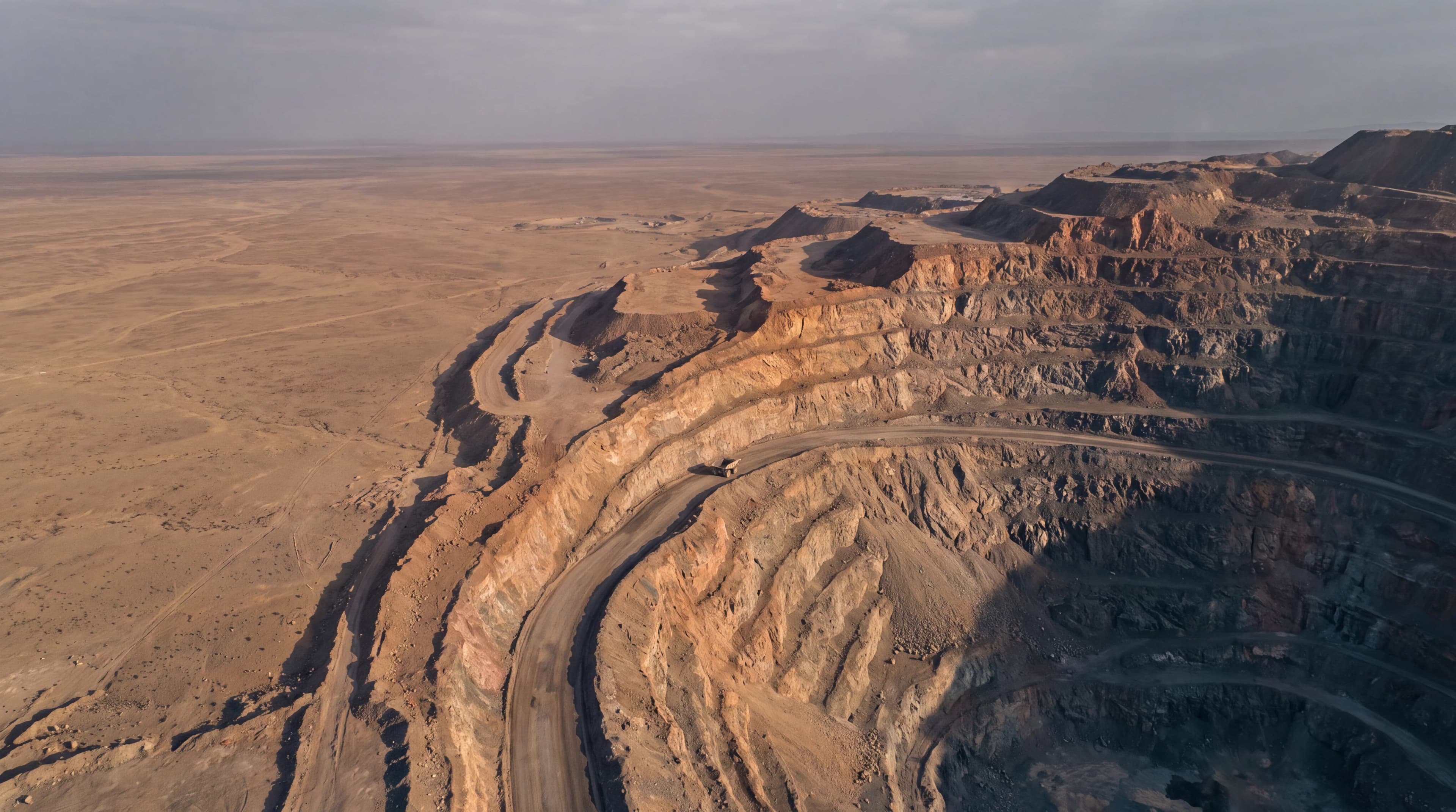 Aerial view of a terraced open-pit mine in an arid landscape